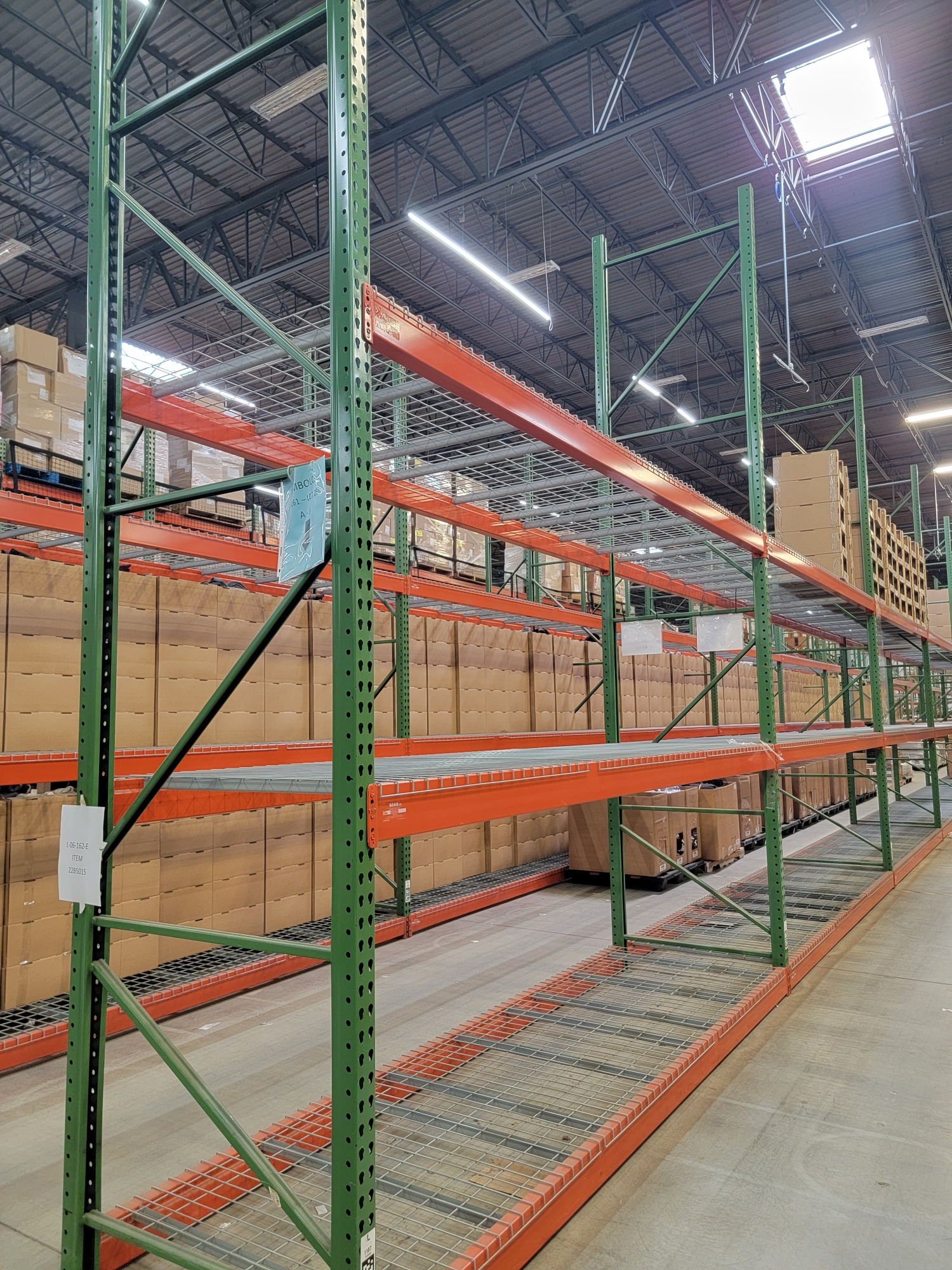 New and used pallet racks in warehouse aisle